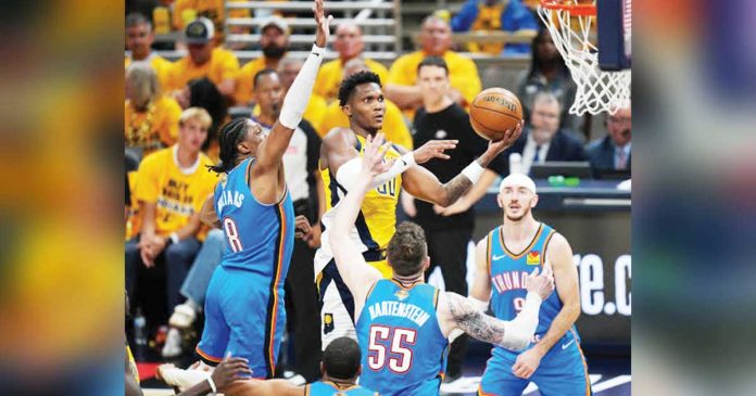 sports-Indiana_superimposed Indiana Pacersā Bennedict Mathurin goes up for a layup in between Oklahoma City Thunder defenders. GETTY IMAGES