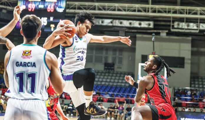 sports_Fiber_resized Converge FiberXers’ Bryan Santos grabs the rebound as San Miguel Beermen’s Jaymar Perez looks on. PBA PHOTO