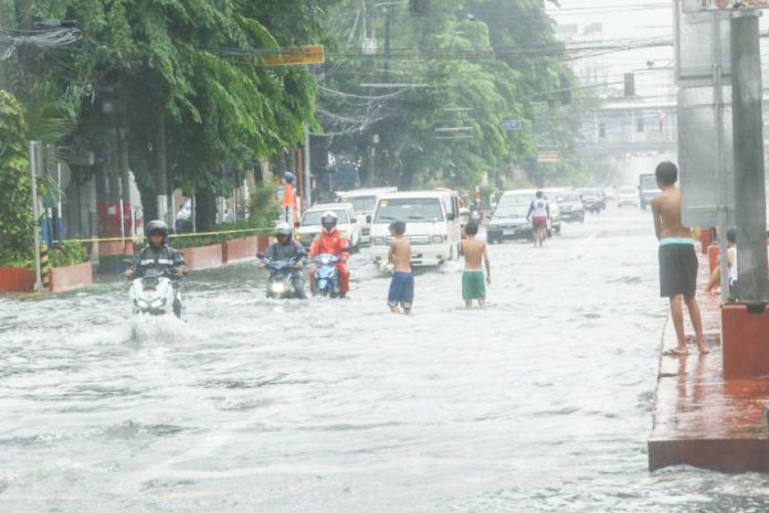 Residents of Barangay Frances, Calumpit, Bulacan wade through knee-deep floodwaters caused by the southwest monsoon (habagat). The town is under a state of calamity. PNA