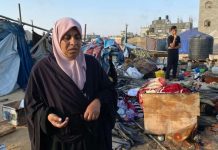 A Palestinian woman inspects the damage to a camp housing displaced people in Khan Younis, after an Israeli strike on July, 2. AFP
