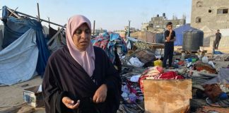 A Palestinian woman inspects the damage to a camp housing displaced people in Khan Younis, after an Israeli strike on July, 2. AFP