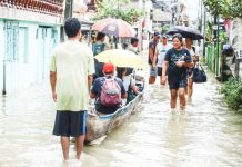 Residents of Barangay Frances, Calumpit, Bulacan wade through knee-deep floodwaters caused by the southwest monsoon (habagat). The town is under a state of calamity. PNA