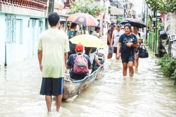 Residents of Barangay Frances, Calumpit, Bulacan wade through knee-deep floodwaters caused by the southwest monsoon (habagat). The town is under a state of calamity. PNA
