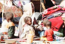 War crimes being committed in Sudan – ICC A woman and five young children sit amid piles of fabric, clothing and matting, under makeshift tents that have been propped up by small trees in Sudan where 12 million people have been displaced by conflict. REUTERS