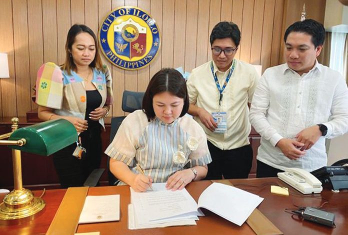 mai_first_day_copy_resized Mayor Raisa Treñas signs her first executive orders as Iloilo City’s new chief executive on Monday, June 30, marking the start of her administration. Witnessing the ceremonial signing are key members of her team. MAI LADIAO/PN