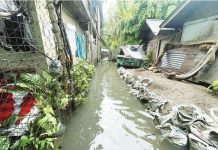 FLOODWATERS RISE IN TAGBAK. Knee-deep flooding inundates a residential alley in Barangay Tagbak, Jaro, Iloilo City on July 20, 2025, following days of heavy rain. Local officials and residents blame nearby Department of Public Works and Highways’ infrastructure projects for obstructing natural drainage paths, worsening the flood situation. PHOTO BY JENNY ROSE CAOYONAN PHOTO