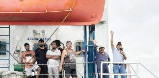 Filipino and Indian crew members of MV Hirman Star wave from the deck of their problematic vessel. They were rescued following weeks of being stuck off Loboc Port, Iloilo City due to the vessel’s unseaworthy condition and unresolved violations. PHOTO BY CONG. JULIENNE BARONDA