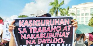 A protester holds a placard demanding job security and a living wage during a protest rally in front of the Iloilo Provincial Capitol on July 28, 2025, joining other activists from across Western Visayas who called for urgent government reforms amid President Ferdinand “Bongbong” Marcos Jr.’s State of the National Address. AJ PALCULLO/PN