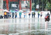 The Department of Labor and Employment says employers in the private sector may suspend work to ensure the safety and health of their employees during weather disturbances. Photo shows commuters waiting for rides in Quezon City amid rains. PNA PHOTO BY ROBERT OSWALD P. ALFILER
