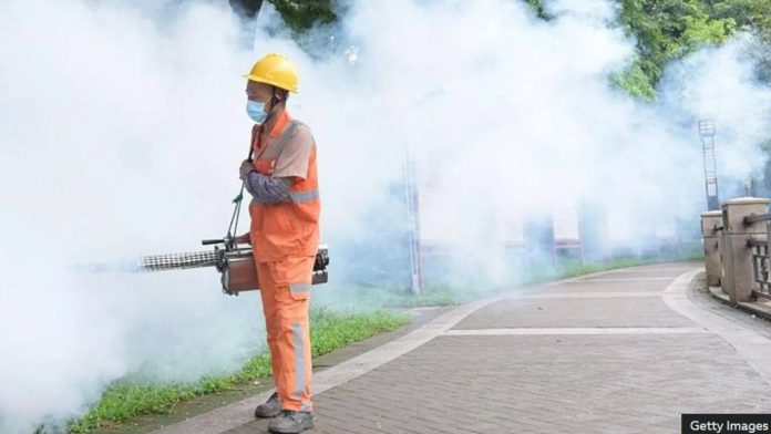 A sanitation worker sprays insecticide to prevent the spread of chikungunya in Dongguan, Guangdong, China. GETTY IMAGES