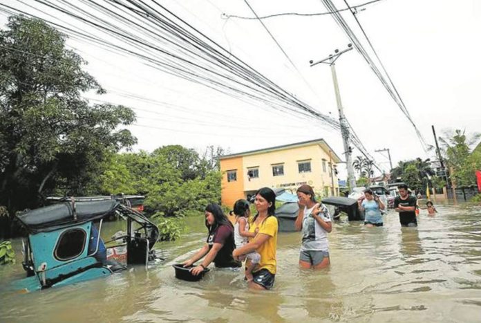DPWH_admits.JPG_resized Residents wade through a flooded main road in Barangay Frances, Calumpit, Bulacan, after days of heavy rain. Photo taken July 31, 2023. Sen. Jinggoy Estrada revealed that his office had received complaints regarding supposed ghost flood control projects in the Bulacan towns of Calumpit, Malolos, and Hagonoy. INQUIRER PHOTO