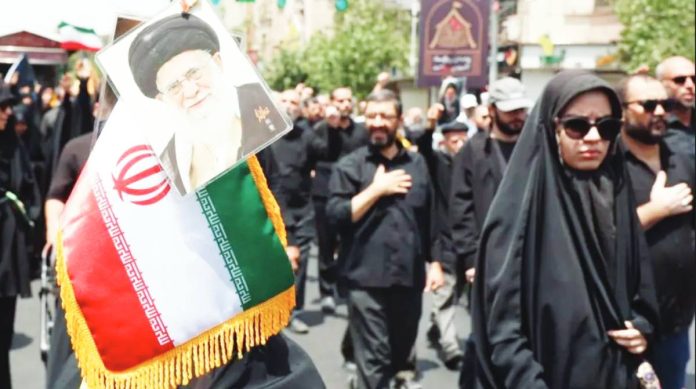 Iranians march with the Iranian flag and a picture of Iranian Supreme Leader Ayatollah Khamenei. EPA