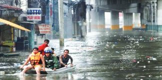 Members of the Quezon City disaster risk reduction and management office use a boat to ferry stranded people along G. Araneta Ave. in Quezon City after flooding hits most of Metro Manila roads at the height of habagat and several typhoons. INQUIRER / MARIANNE BERMUDEZ