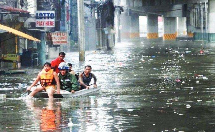 July 21 2025 Quezon city DRRMO use a boat to ferry stranded people along G. Araneta Ave. in Quezon city after flooding during heavy rains due to the Southwest Monsoon (Habagat) triggered floods in several areas in Metro Manila on Monday.INQUIRER/ MARIANNE BERMUDEZ Members of the Quezon City disaster risk reduction and management office use a boat to ferry stranded people along G. Araneta Ave. in Quezon City after flooding hits most of Metro Manila roads at the height of habagat and several typhoons. INQUIRER / MARIANNE BERMUDEZ