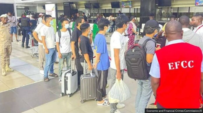 Foreigners wearing facemasks line up at airport check-in counters in Nigeria – some with luggage. They are being deported. Economic and Financial Crimes Commission/X