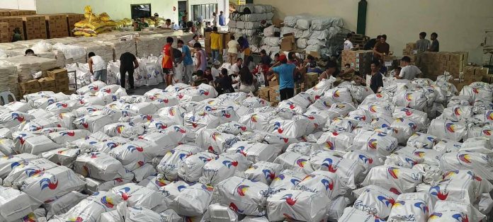 PHOTO 1 Volunteer employees pack thousands of relief goods at PAGCOR's warehouse in Imus, Cavite. The food and non-food relief packs are then picked up in batches by recipient local government units and agencies.