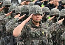 South Korean soldiers standing in neat rows, raising their hands in salute. The nation’s military has fallen below the 500,000 threshold that experts say is needed to maintain defense readiness. GETTY IMAGES