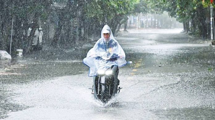 A motorbike rider wades through a partly flooded street during heavy rains in Vietnam. GETTY IMAGES