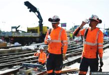WHO warns of risks of extreme heat in workplace Laborers wearing hi-viz orange tops drink water to cool down as they work on a construction site of tramway lines along the Garonne river in France. The World Health Organization has said that climate change will leave construction workers especially vulnerable to heat stress. AFP