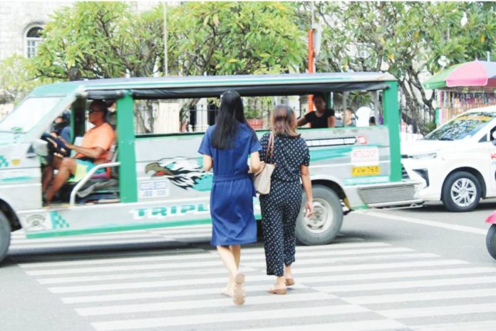 A mother and her daughter cross a pedestrian lane in Jaro, Iloilo City where advocates are calling for stronger human immunodeficiency virus awareness efforts that include not just the youth but also parents, whose beliefs can shape access to life-saving education and prevention tools. AJ PALCULLO/PN