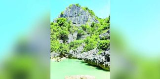 The emerald waters of Tangke Saltwater Lagoon in Carles, Iloilo, are framed by towering limestone cliffs. The local government has ordered its temporary closure this September to ensure visitor safety during the southwest monsoon and allow the natural attraction to recover. MAI LADIAO/PN