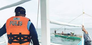 An Iloilo Provincial Bantay Dagat member and a police officer intercept a fishing boat off the coast of Carles, Iloilo during an anti-illegal fishing operation on August 4, 2025. Six suspects were apprehended for alleged dynamite fishing. PHOTO FROM BALITA HALIN SA KAPITOLYO