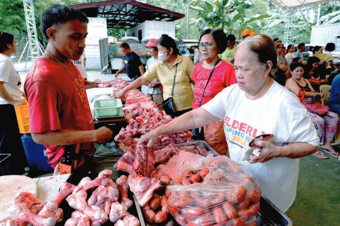 Elderly customers buy fresh pork meat and pork by-products at the Kadiwa store of the Bureau of Animal Industry in Diliman, Quezon City. PNA PHOTO BY BEN BRIONES