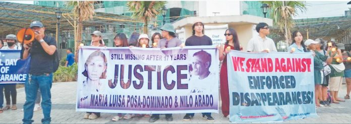 18 years copy Families and human rights advocates hold a candlelight protest in Iloilo City on August 30, 2025, calling for justice for missing activists Maria Luisa Posa-Dominado and Nilo Arado, who were abducted 18 years ago, and demanding an end to enforced disappearances. PANAY ALLIANCE-KARAPATAN PHOTO