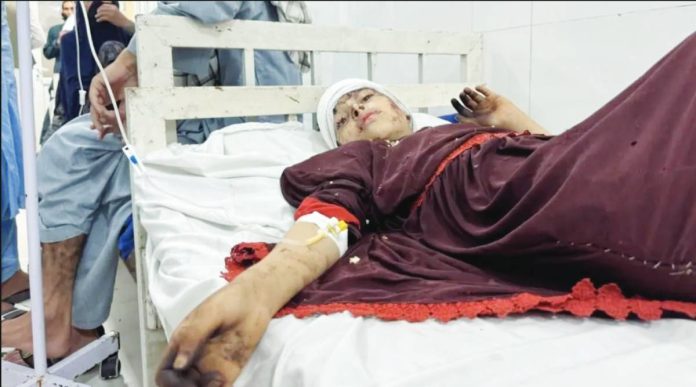 An injured earthquake victim is lying down in a hospital bed, with a drip in their right arm, the head bandaged, and the face showing injuries. Hospitals in Afghanistan - already under strain - are reported to be overwhelmed by earthquake victims. EPA