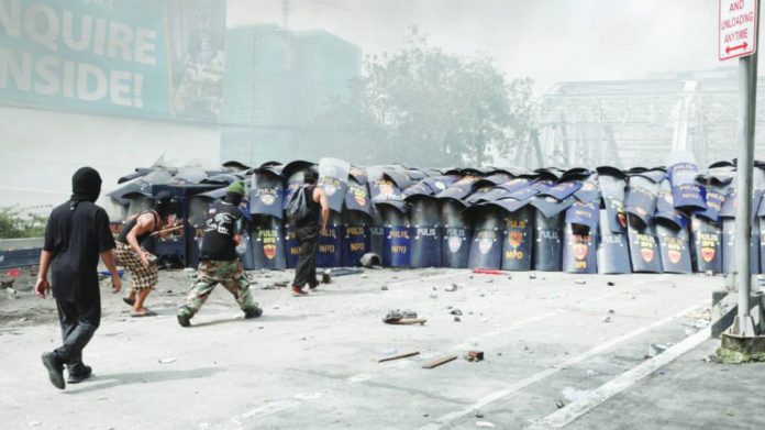 UNDER SIEGE. The anti-riot unit of the Manila Police District uses shields during a rowdy protest at the approach of Ayala Bridge in Manila on Sept. 21, 2025. The police arrested an initial 17 suspects. PNA