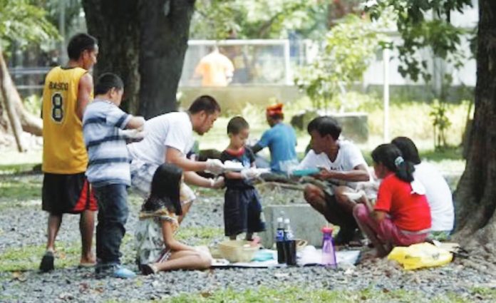 A family enjoys a meal at a picnic spot in Rizal Park in Manila in this undated photo. Malacañang issued Memorandum Circular 96 suspending work in government offices under the executive branch from 1 p.m. onwards today, Sept. 22, in line with the observance of the 33rd National Family Week. PNA