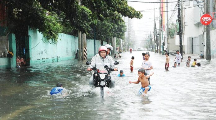 Greenpeace_copy_resized A FLOOD OF INCONVENIENCE. A motorcycle negotiates a flooded street in Makati City while children, unmindful of health dangers, play. Inclement weather usually brings rains that submerge in floods the streets of Metro Manila. PNA