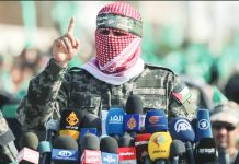 Hamas spokesman Abu Obeida speaks behind a number of microphones with logos of world media while wearing a scarf over his face, flanked by two Hamas fighters. Obeida often delivered long diatribes against Israel, always masked in a Palestinian scarf. GETTY IMAGES