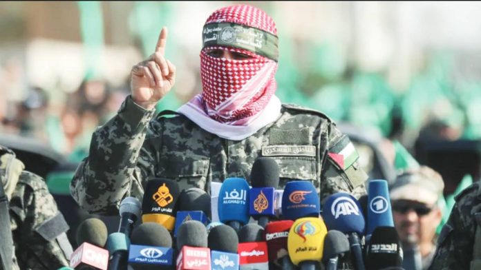 Hamas Hamas spokesman Abu Obeida speaks behind a number of microphones with logos of world media while wearing a scarf over his face, flanked by two Hamas fighters. Obeida often delivered long diatribes against Israel, always masked in a Palestinian scarf. GETTY IMAGES