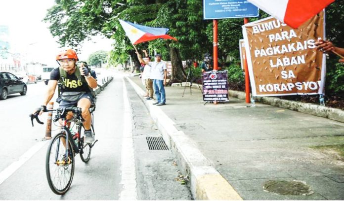 Marcos backs copy “Bumusina para pagkaka-isa laban sa korapsyon” (Blow your horns for unity against corruption), reads a giant banner near the People Power monument along EDSA in Quezon City. On Sunday, a mass action against corruption was held in various parts of the country. PNA