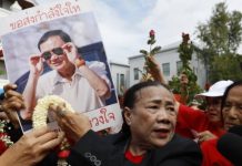 Supporters of Thaksin wearing his party's trademark red colour showed up at the court on Tuesday. EPA