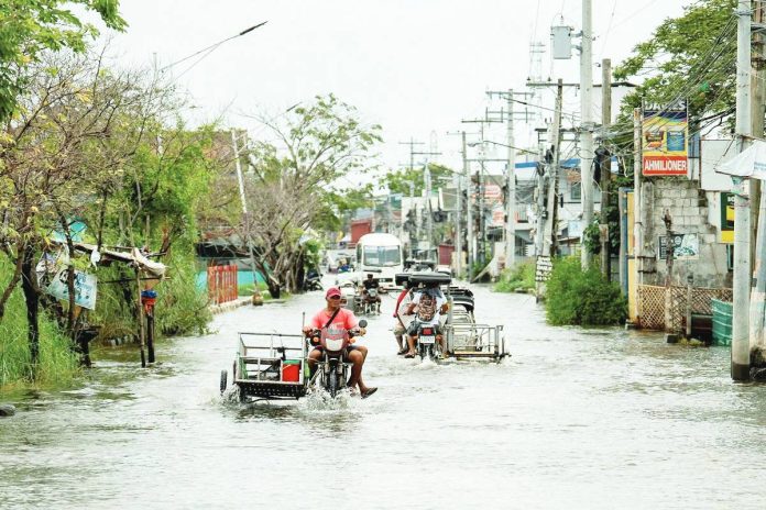 Motorists wade through a flooded road, following heavy rains intensified by Super Typhoon “Nando”, in Apalit, Pampanga, on Sept. 23, 2025. REUTERS/ LISA MARIE DAVID PHOTO