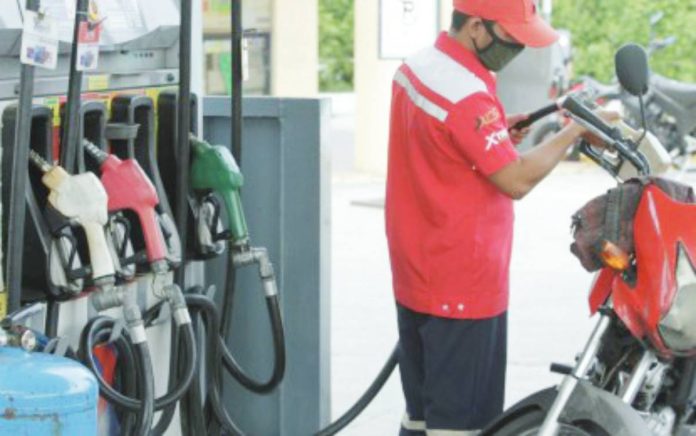 A gasoline station attendant refills a motorcycle of a customer in this undated photo. Oil companies announced on Monday, Sept. 29, 2025, price reduction in gasoline products but hikes in the prices of diesel and kerosene effective Tuesday, Sept. 30. PNA FILE PHOTO