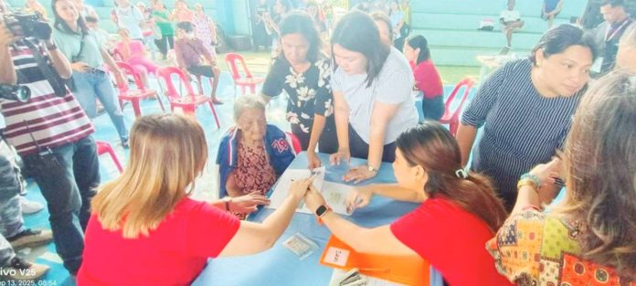 A senior citizen in Iloilo City receives her P10,000 milestone cash gift under the Expanded Centenarians Act of 2023 during a payout ceremony in Barangay Quintin Salas, Jaro district on Sept. 13, 2025. “While waiting for their payout, we made sure our lolo and lola had time to relax. We provided free haircuts, manicures, and massage services so that it felt more like a celebration than just a distribution,” says Mayor Raisa Treñas (standing, right). DYRI RMN ILOILO PHOTO
