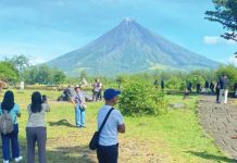 Tourists enjoy the clear view of Mayon Volcano in Cagsawa Ruins in Daraga, Albay province on Feb. 1, 2025. The Department of Tourism on Tuesday, Sept. 2, told a congressional budget hearing that the tourism sector is projected to generate P2.7 trillion for the Philippine economy this year. PNA FILE PHOTO BY CONNIE CALIPAY