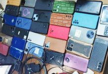A closeup of different brands of seized phones and chargers placed on a table. These were used to carry out sextortion and romance scams in the African continent, according to Interpol. INTERPOL