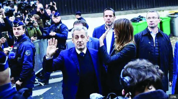 France.JPG_resized_compressed Former French President Nicolas Sarkozy and his wife wave at crowds and photographers on the street before he goes to prison. EPA