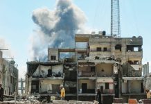 Smoke billows behind this building in Gaza City bombed by Israel. EPA