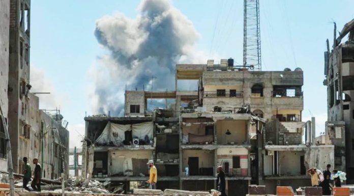 Smoke billows behind this building in Gaza City bombed by Israel. EPA