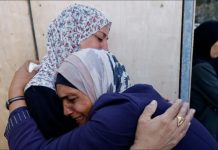 Women hug each other during the funeral of Palestinians killed in Israeli strikes, at al-Awda Hospital, in central Gaza. REUTERS