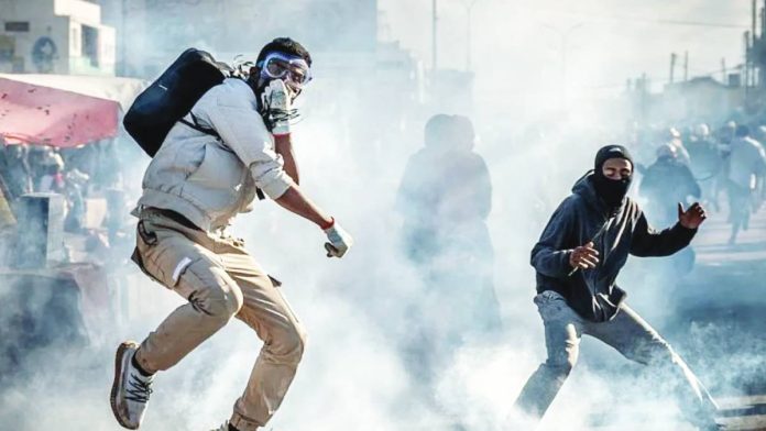 Madagascar A protester wearing a gas mask jumps to avoid a teargas canister during clashes with Malagasy security forces. Protests in major cities across Madagascar have entered their third week. AFP VIA GETTY IMAGES