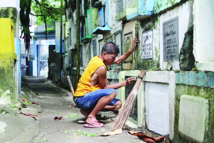 Mai_Tanza_worker_copy_resized_compressed Fifty-eight-year-old Fernando Bugna dedicates his 20 years cleaning and repainting graves at Tanza Cemetery in Iloilo City – a humble yet steady livelihood that has quietly sustained his family. AJ PALCULLO/PN