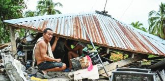 A MAN looks for items in a collapsed house in Manay, Davao Oriental on October 11, 2025, after two powerful quakes struck on October 10, killing at least eight people and triggering tsunami warnings. AFP