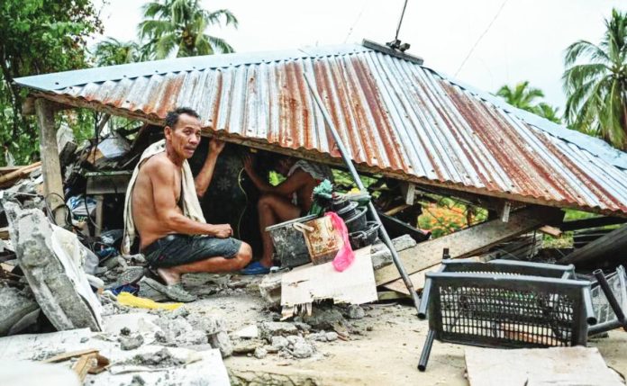 Marcos orders copy A MAN looks for items in a collapsed house in Manay, Davao Oriental on October 11, 2025, after two powerful quakes struck on October 10, killing at least eight people and triggering tsunami warnings. AFP
