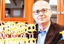 Chemistry professor Omar Yaghi poses in his lab at the University of California in Berkeley US. Next to him is a model showing metal-organic frameworks made of yellow and red tubes and nodes. REUTERS